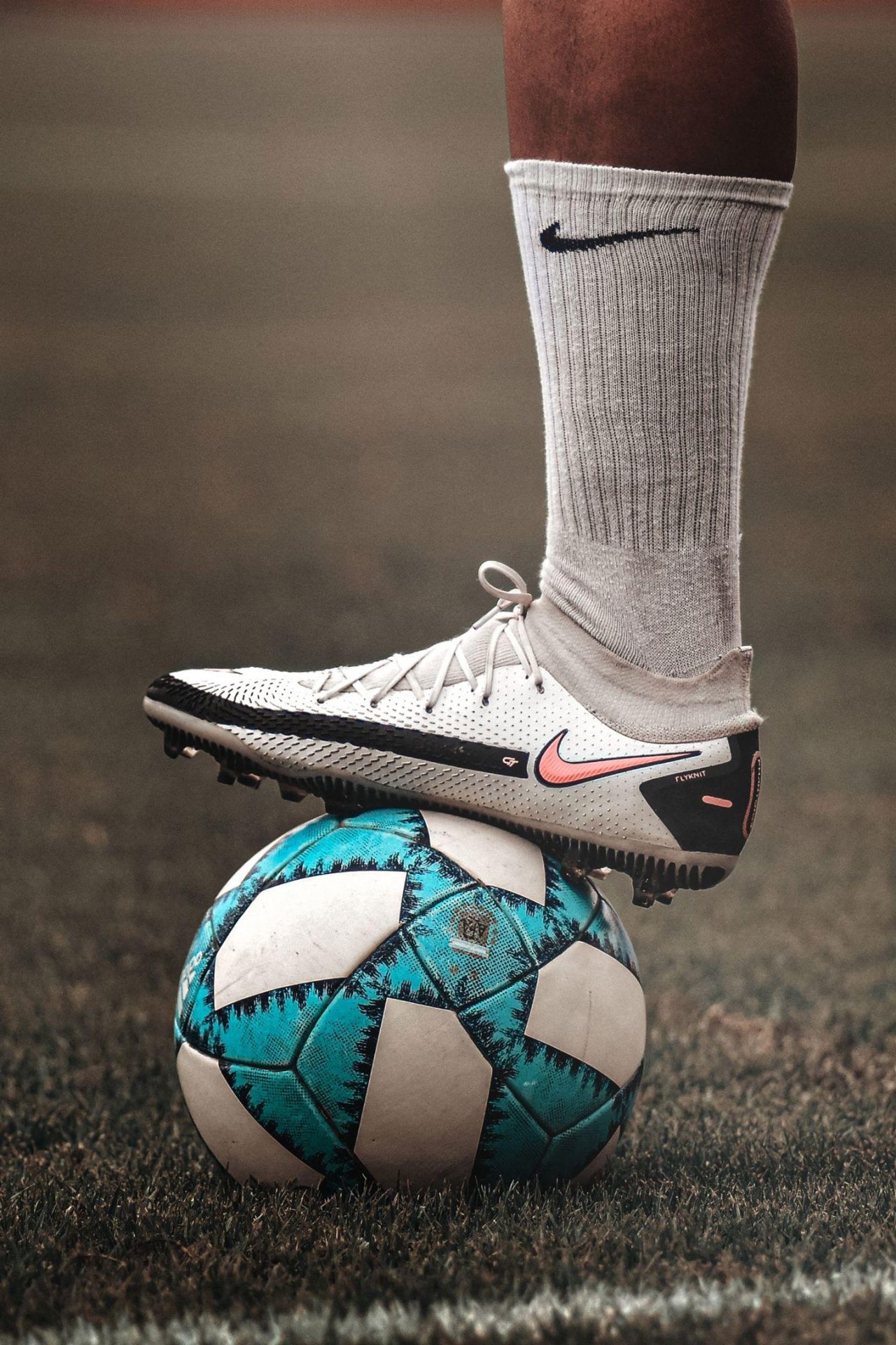 A person in sportswear balancing a blue socce